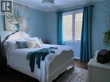 Plympton-Wyoming apartment for rent - A bedroom with a white bed and a painting on the wall.