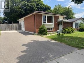 Brampton (Madoc) apartment for rent - A house with a driveway and a green bench in front of it.
