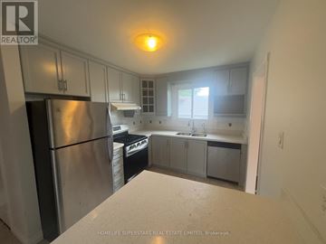 Brampton (Madoc) apartment for rent - A kitchen with a refrigerator, sink, and cabinets.