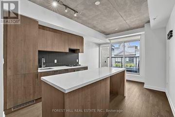 Toronto (Trinity-Bellwoods) condo for rent - A modern kitchen with wooden cabinets and a large island.