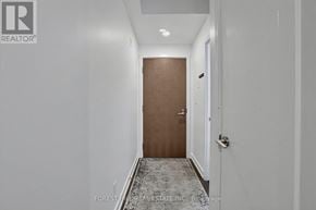 Toronto (Trinity-Bellwoods) condo for rent - A hallway with a wooden door and a carpeted floor.