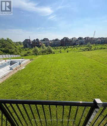 Vaughan (Kleinburg) apartment for rent - A green field with a fence in the foreground and houses in the background.