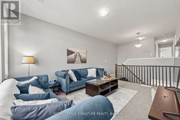 Guelph (Grange Road) apartment for rent - A living room with a blue couch and a painting on the wall.