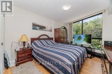 Hamilton (Corktown) condo for rent - A bedroom with a bed, dresser, and a painting on the wall.