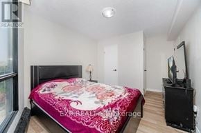 Hamilton (Corktown) condo for rent - Bedroom with a bed, a television, and a window.