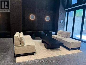 Toronto (Mount Pleasant West) condo for rent - A modern living room with a beige sofa and a black coffee table.