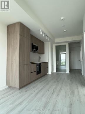 Toronto (Mount Pleasant West) condo for rent - A modern kitchen with wooden cabinets and a grey floor.