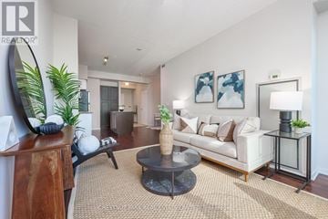 Toronto (Niagara) condo for rent - A living room with a white couch, a coffee table, and a painting on the wall.