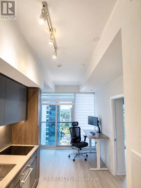 Toronto (Church-Yonge Corridor) condo for rent - A modern kitchen with a desk and chair in front of a window.