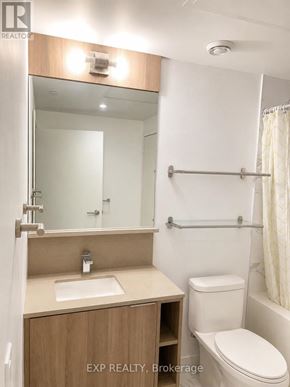 Toronto (Church-Yonge Corridor) condo for rent - A bathroom with a toilet, sink, mirror, and towel rack.