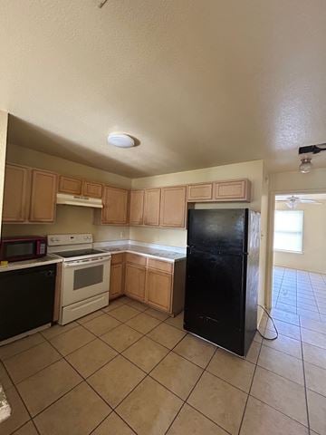 Temple apartment for rent - A kitchen with black appliances and brown cabinets.