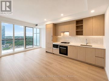 Toronto (Bayview Village) condo for rent - A kitchen with wooden floors and a large window overlooking a balcony.
