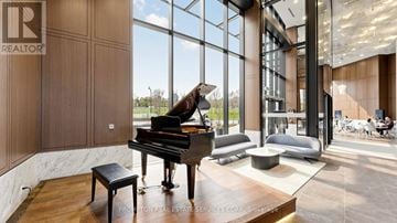 Toronto (Bayview Village) condo for rent - A grand piano sits in a spacious room with a view of the outdoors.