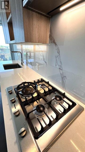 Toronto (Bayview Village) condo for rent - A stainless steel gas stove with four burners is in a kitchen.