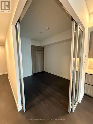Toronto (Bayview Village) condo for rent - A room with a sliding door and a dark floor.