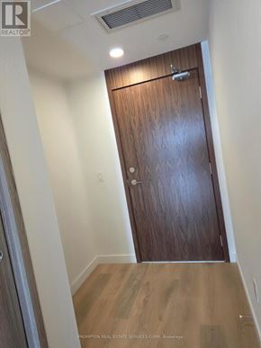 Toronto (Bayview Village) condo for rent - A wooden door in a hallway with a light on the ceiling.