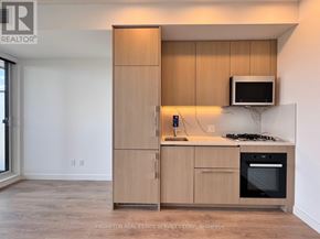 Toronto (Bayview Village) condo for rent - A kitchen with a microwave oven and a stove top oven.