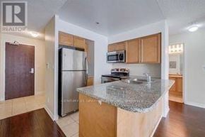 Mississauga (Creditview) condo for rent - A kitchen with a granite countertop and wooden cabinets.