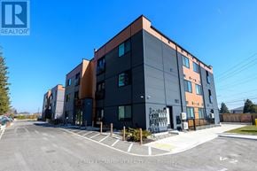Hamilton (Stoney Creek) condo for rent - A modern building with the RE/MAX Escarpment Realty Inc. logo on it.