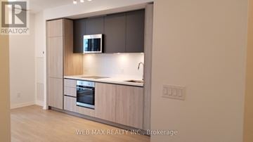 Toronto (Waterfront Communities) condo for rent - A kitchen with a stove top oven and a microwave.