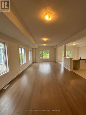 Loyalist (Bath) apartment for rent - A spacious room with wooden floors and a ceiling light.