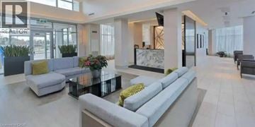 Mississauga condo for rent - A modern living room with a glass table and grey sofas.
