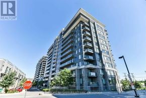 Markham (Commerce Valley) condo for rent - A tall apartment building with a stop sign in front of it.