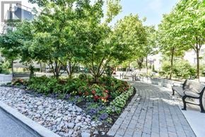 Markham (Commerce Valley) condo for rent - A park with a curved walkway, benches, and a variety of trees and flowers.