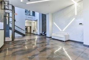 Markham (Commerce Valley) condo for rent - A modern office lobby with a white reception desk and a glass door.