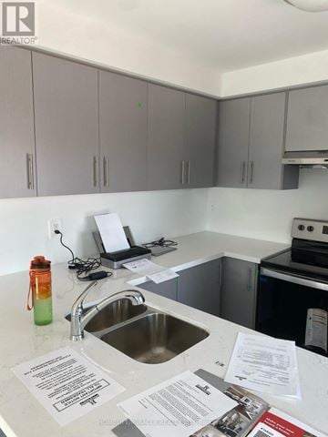 Brampton (Northwest Brampton) townhouse for rent - A kitchen with a sink and a counter with papers on it.