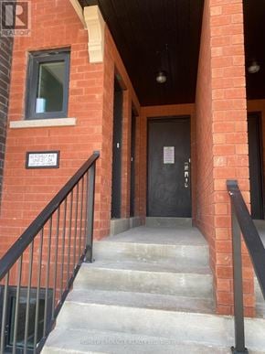 Brampton (Northwest Brampton) townhouse for rent - A brick building with a black door and a sign on the wall.