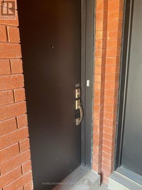 Brampton (Northwest Brampton) townhouse for rent - A black door with a gold handle is set in a brick wall.