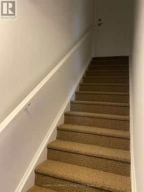 Brampton (Northwest Brampton) townhouse for rent - A staircase with beige carpeted steps and white railings.