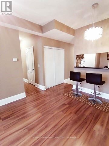 Toronto (New Toronto) condo for rent - A room with wooden floors and a bar area with two stools.