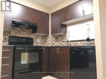 Toronto (New Toronto) condo for rent - A kitchen with dark cabinets and black appliances.