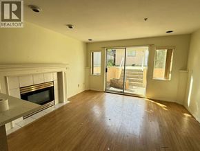 Vancouver apartment for rent - A large empty room with a fireplace and sliding glass doors.