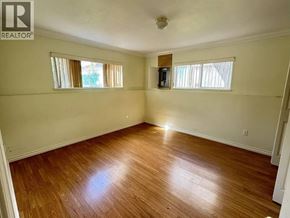 Vancouver apartment for rent - A room with wooden floors and two windows.