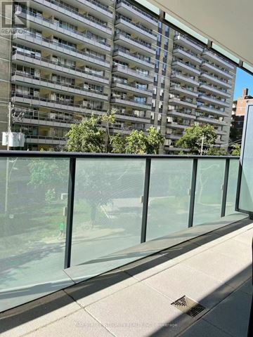 Toronto (Mount Pleasant West) condo for rent - A glass balcony with a building in the background.