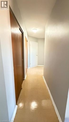Guelph apartment for rent - A long hallway with wooden floors and white walls.