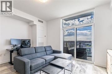 Waterdown condo for rent - A living room with a grey sofa and a television.