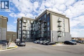 Waterdown condo for rent - A modern apartment building with a parking lot in front.