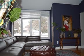 Ottawa apartment for rent - A living room with a grey couch and a painting on the wall.