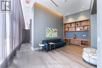 Toronto (Waterfront Communities) condo for rent - A living room with a blue couch and a painting on the wall.