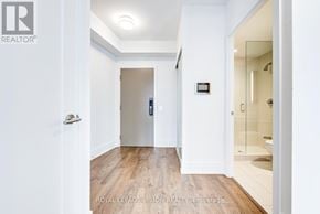 Toronto (Waterfront Communities) condo for rent - A hallway with a door on the left and a bathroom on the right.