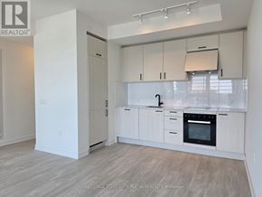 Toronto (Banbury-Don Mills) condo for rent - A white kitchen with wooden floors and a large island.