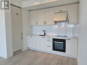 Toronto (Banbury-Don Mills) condo for rent - A kitchen with white cabinets and a black oven.