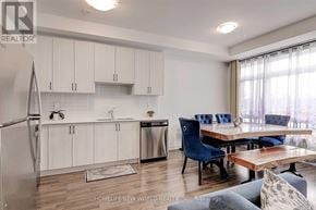 Vaughan (Vaughan Grove) townhouse for rent - A modern kitchen with a refrigerator, sink, and dining table.