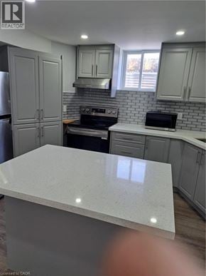 Burlington apartment for rent - A kitchen with a white counter top and grey cabinets.