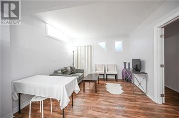 Hamilton (Stoney Creek) apartment for rent - A living room with a white table and chairs.
