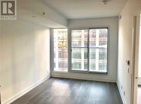 Toronto (Moss Park) condo for rent - A room with a large window and wooden flooring.